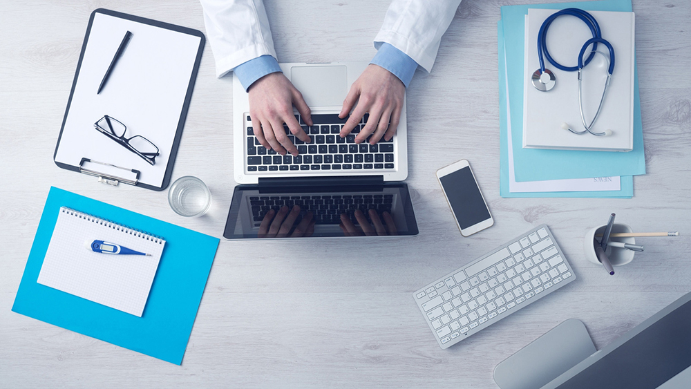 telehealth patient visits doctor typing on a laptop